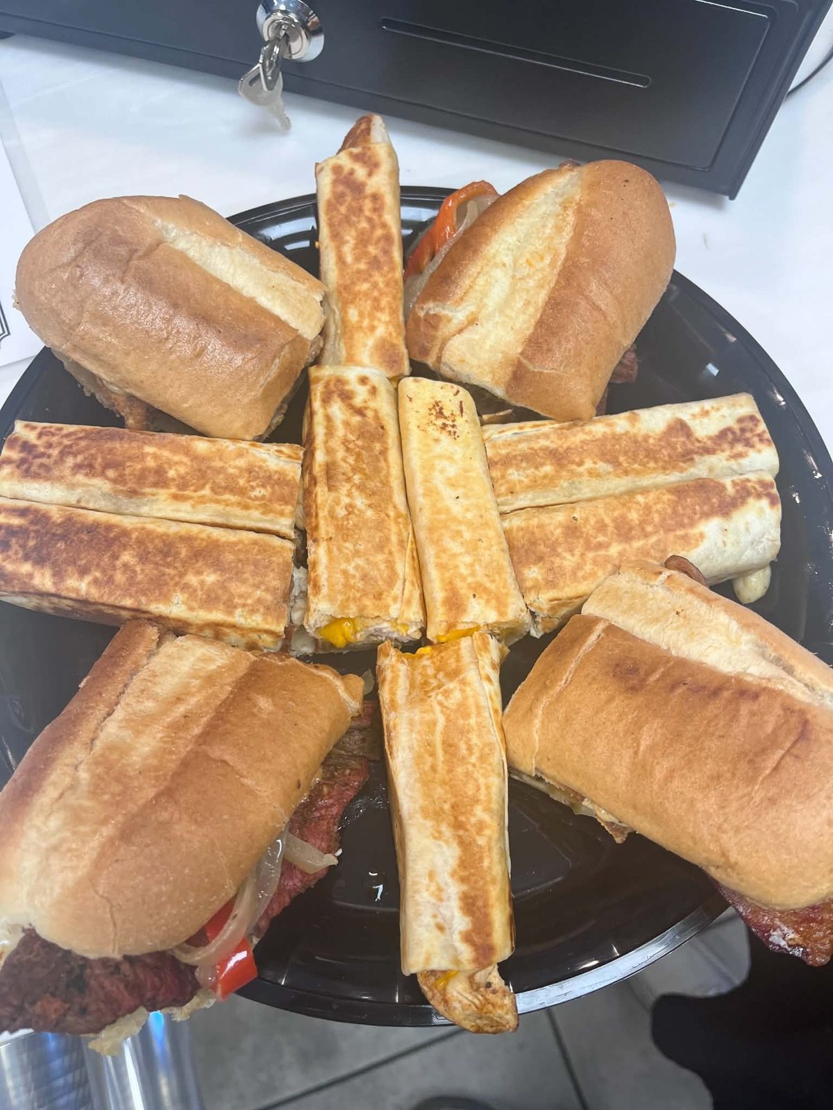 A platter of toasted sandwiches and grilled wraps, seen from above